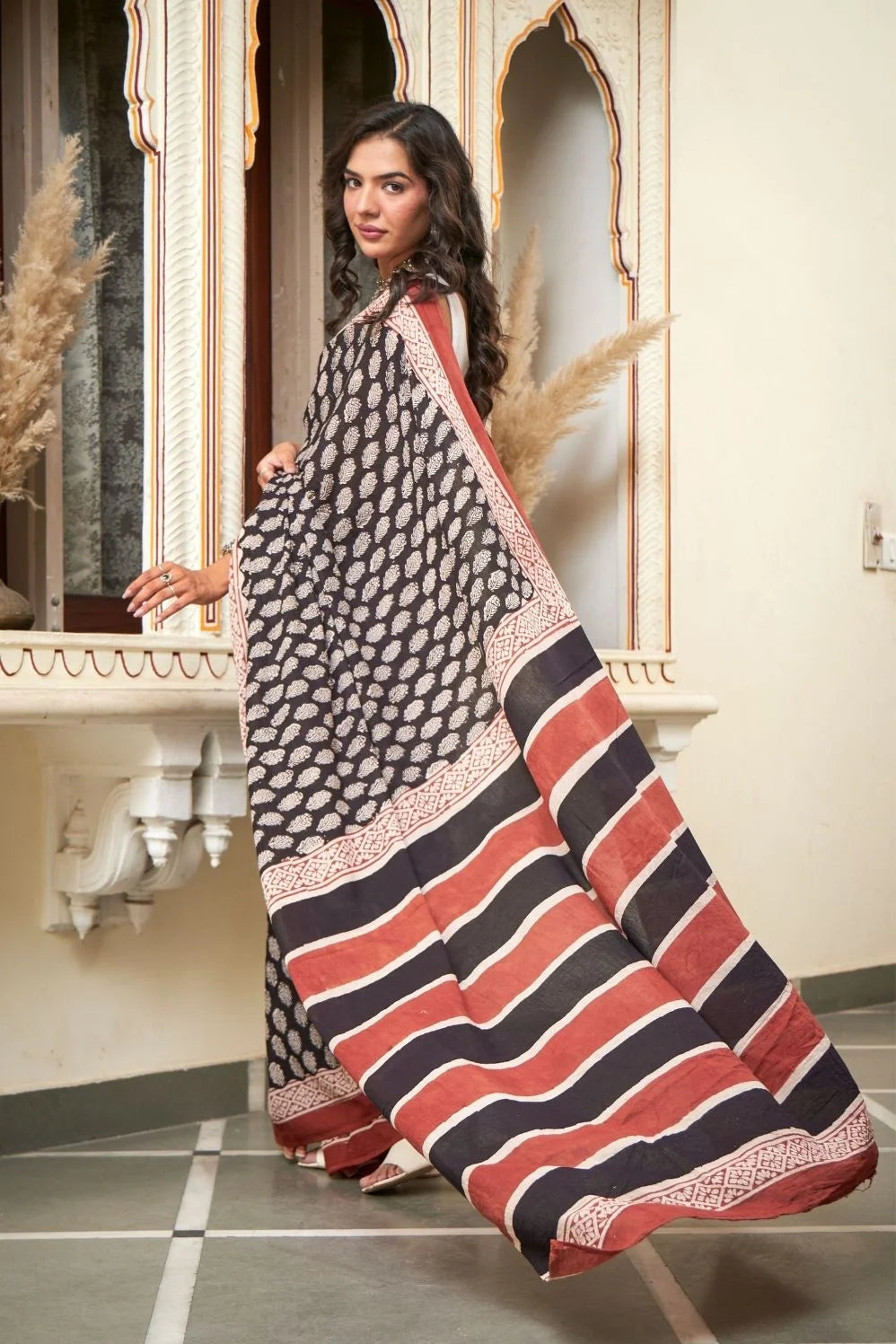 Black mulmul cotton saree with elegant handcrafted motifs.