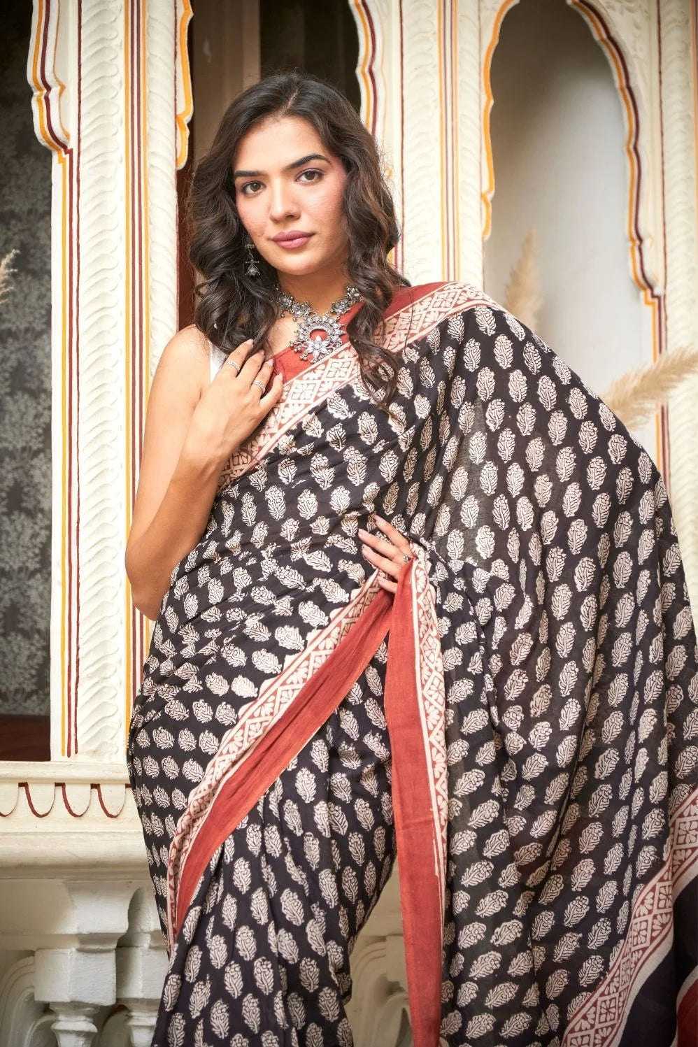 Black mulmul cotton saree with elegant handcrafted motifs.