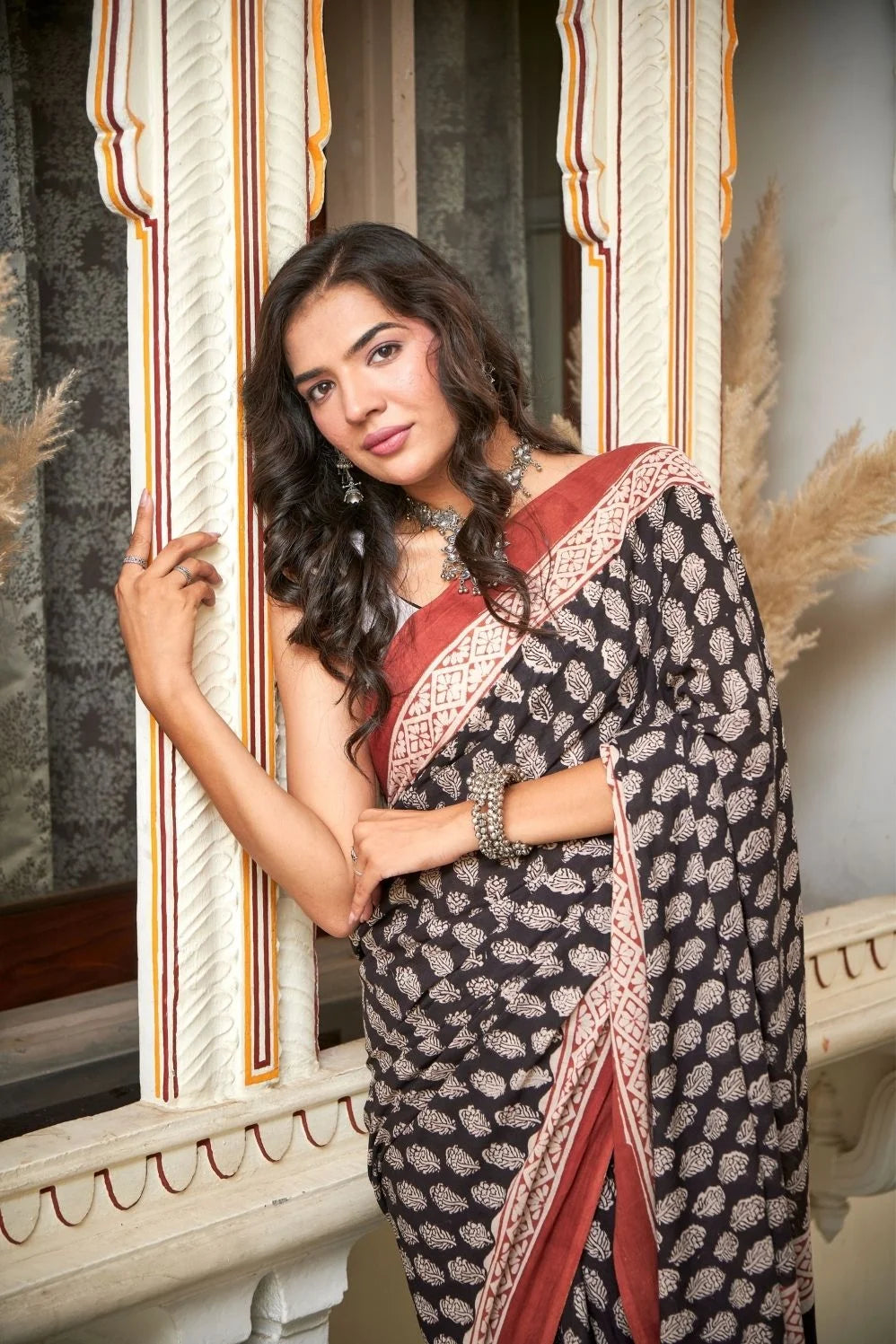 Black mulmul cotton saree with elegant handcrafted motifs.