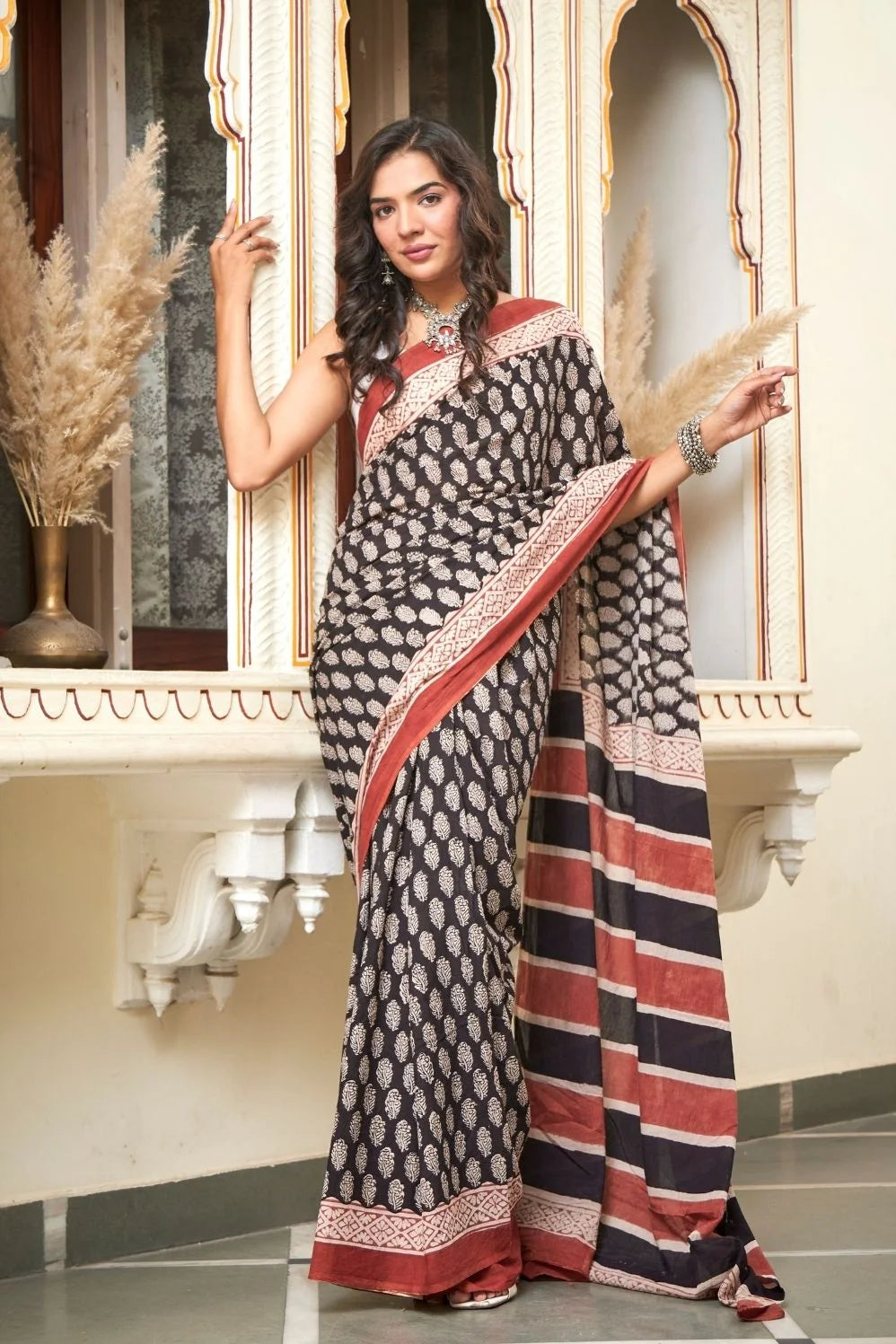 Black mulmul cotton saree with elegant handcrafted motifs.