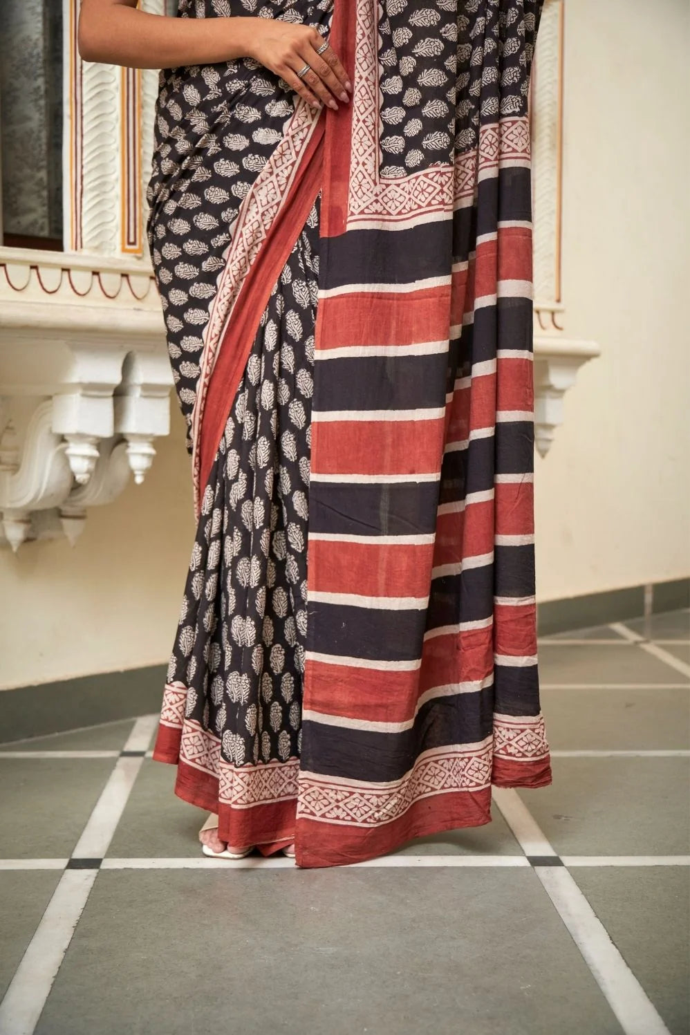Black mulmul cotton saree with elegant handcrafted motifs.