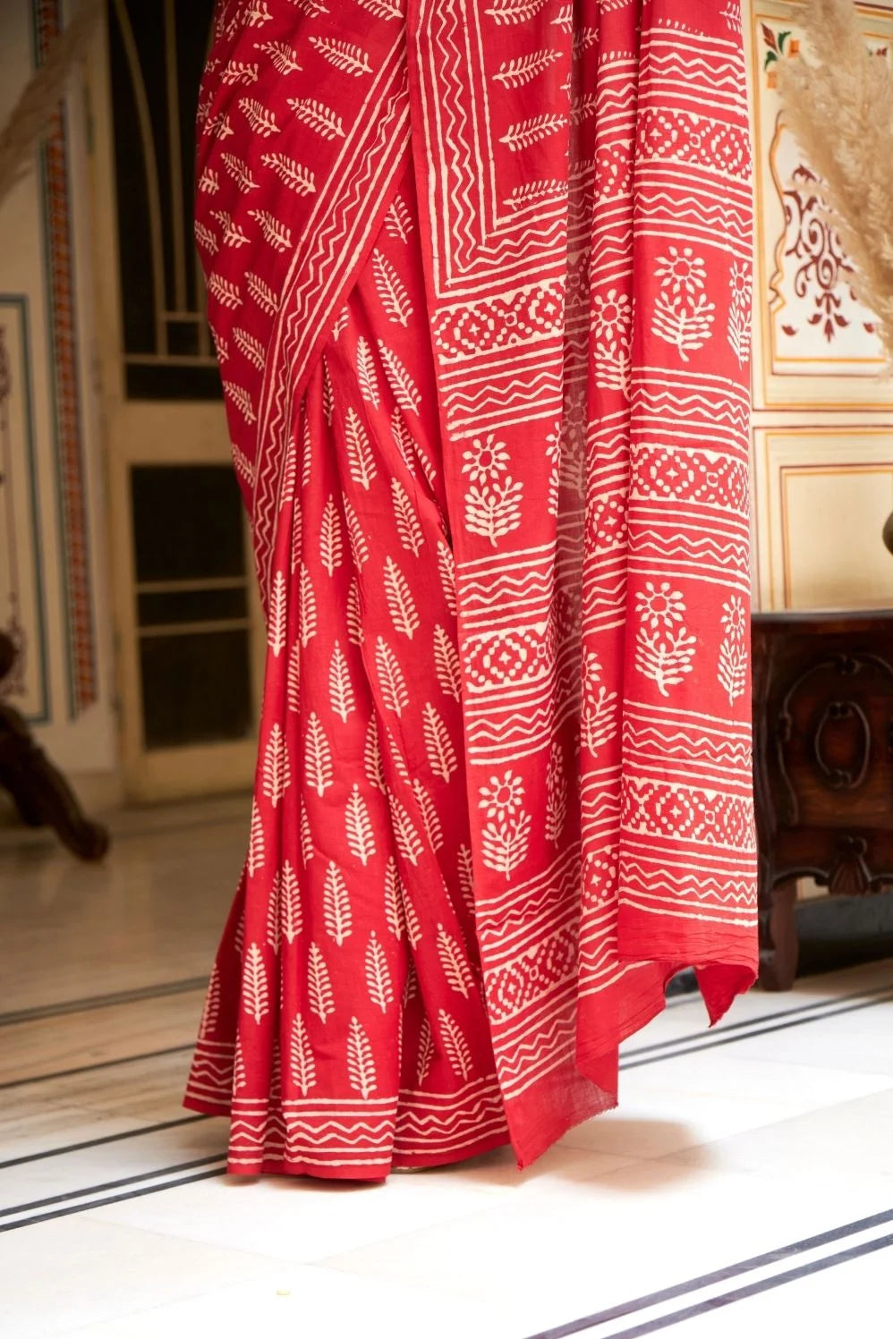 Bright red mulmul cotton saree with handcrafted block prints.