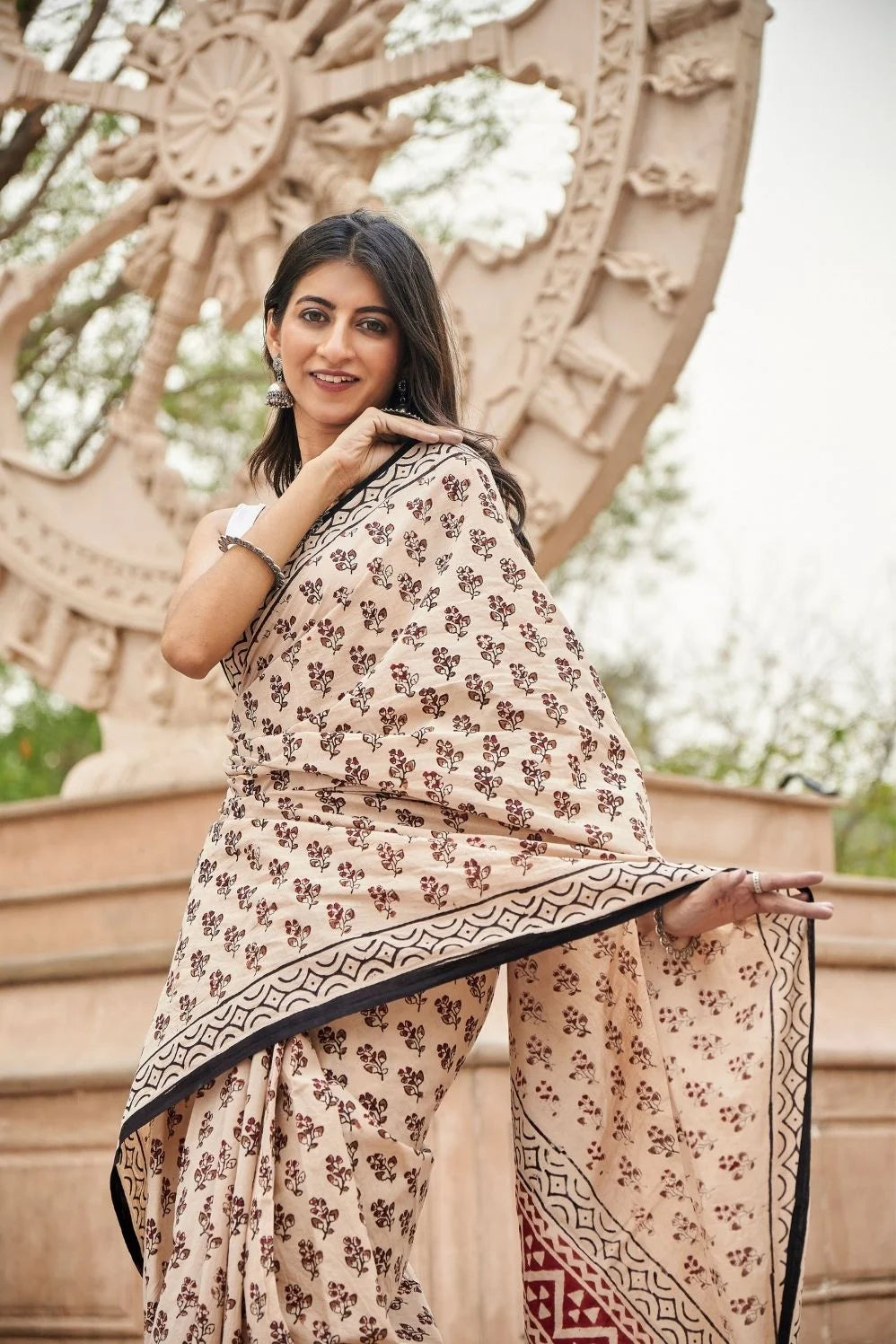 Cream-colored cotton saree with artistic block printing.