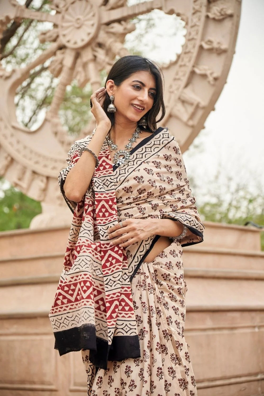 Cream red mulmul cotton saree with artistic block printing.