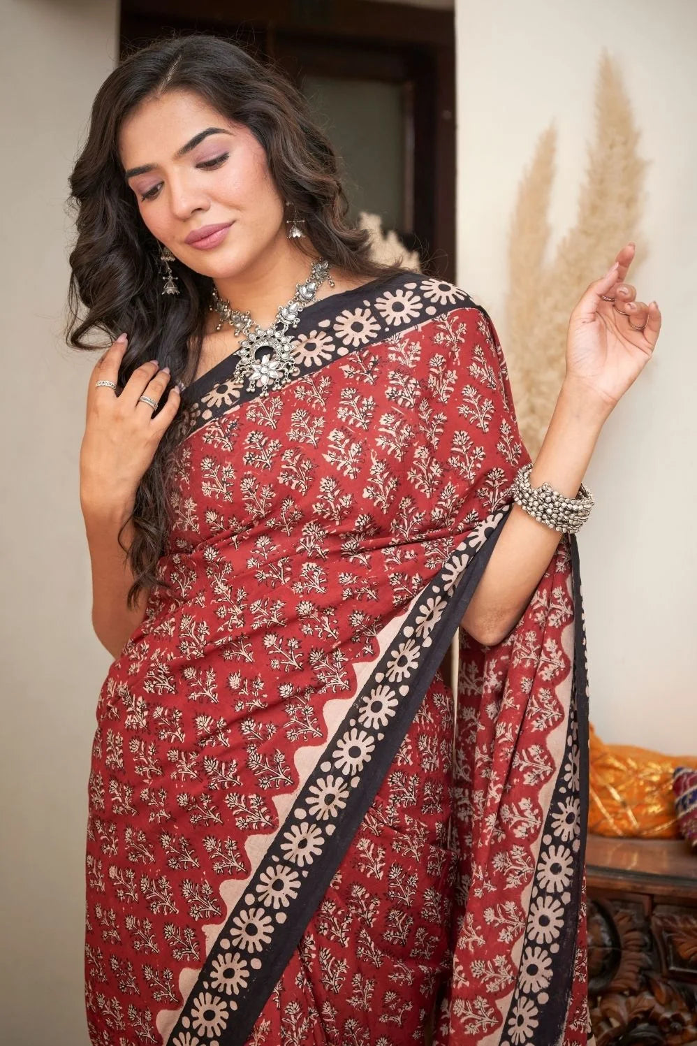 Maroon mulmul cotton saree with intricate hand block patterns.