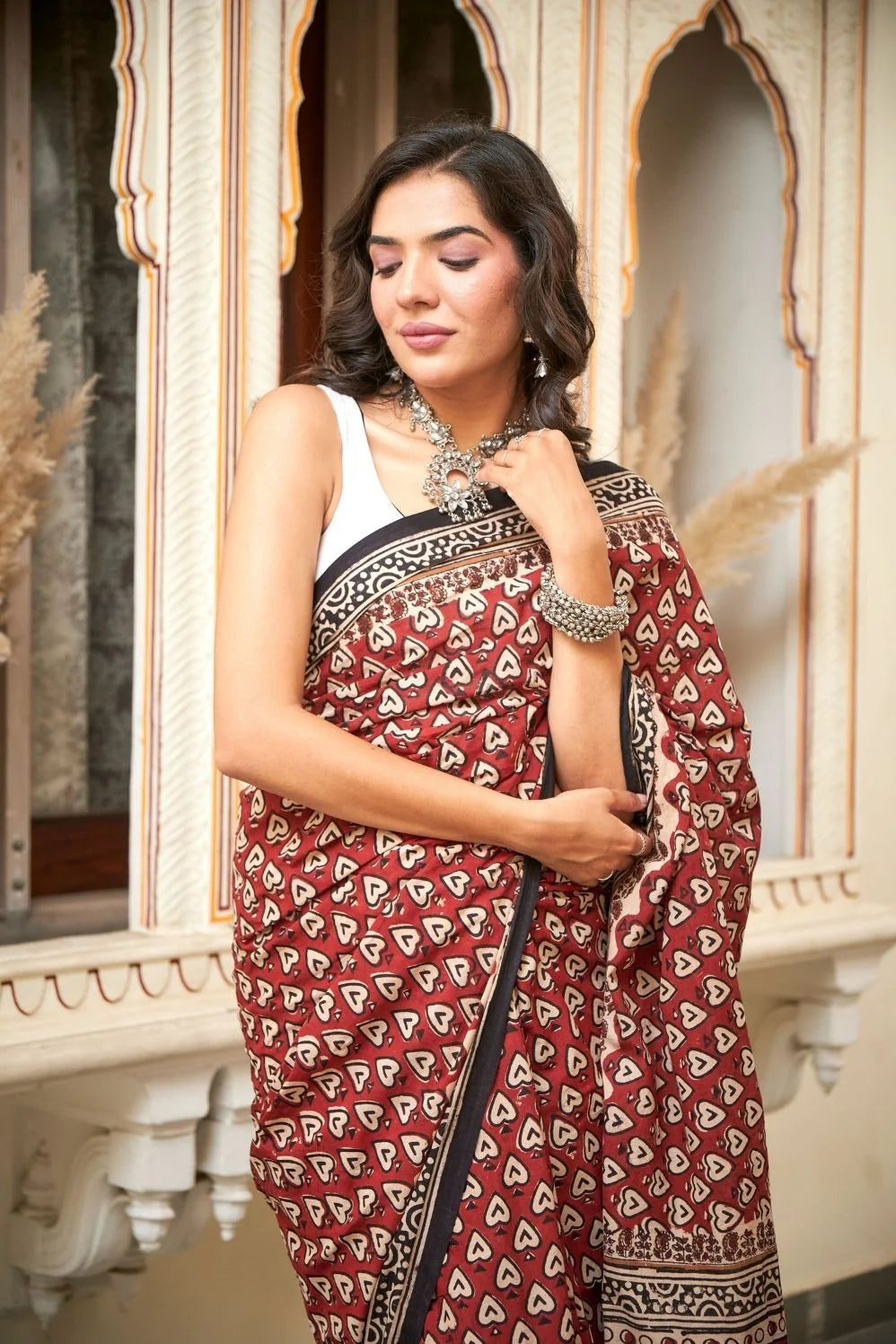Red mulmul cotton saree with heart print designs.