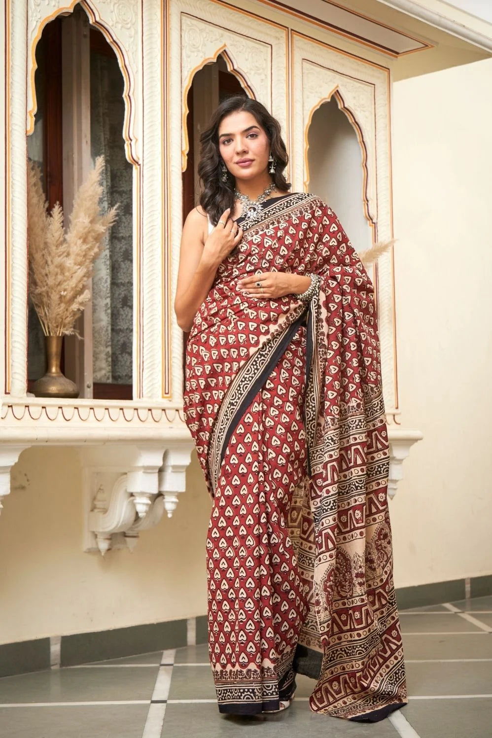 Red mulmul cotton saree with heart print designs.