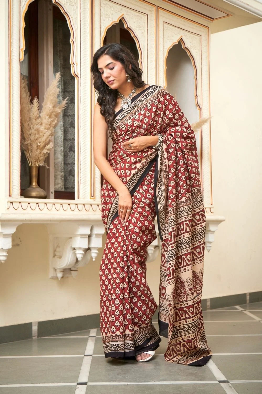 Red mulmul cotton saree with heart print designs.