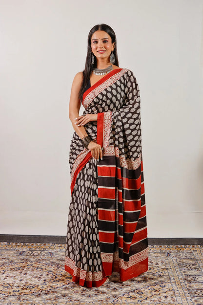 Black hand block print mulmul cotton saree with red border and striped pallu – full front view.